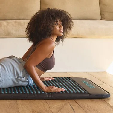 Black woman laying on PEMF Mat