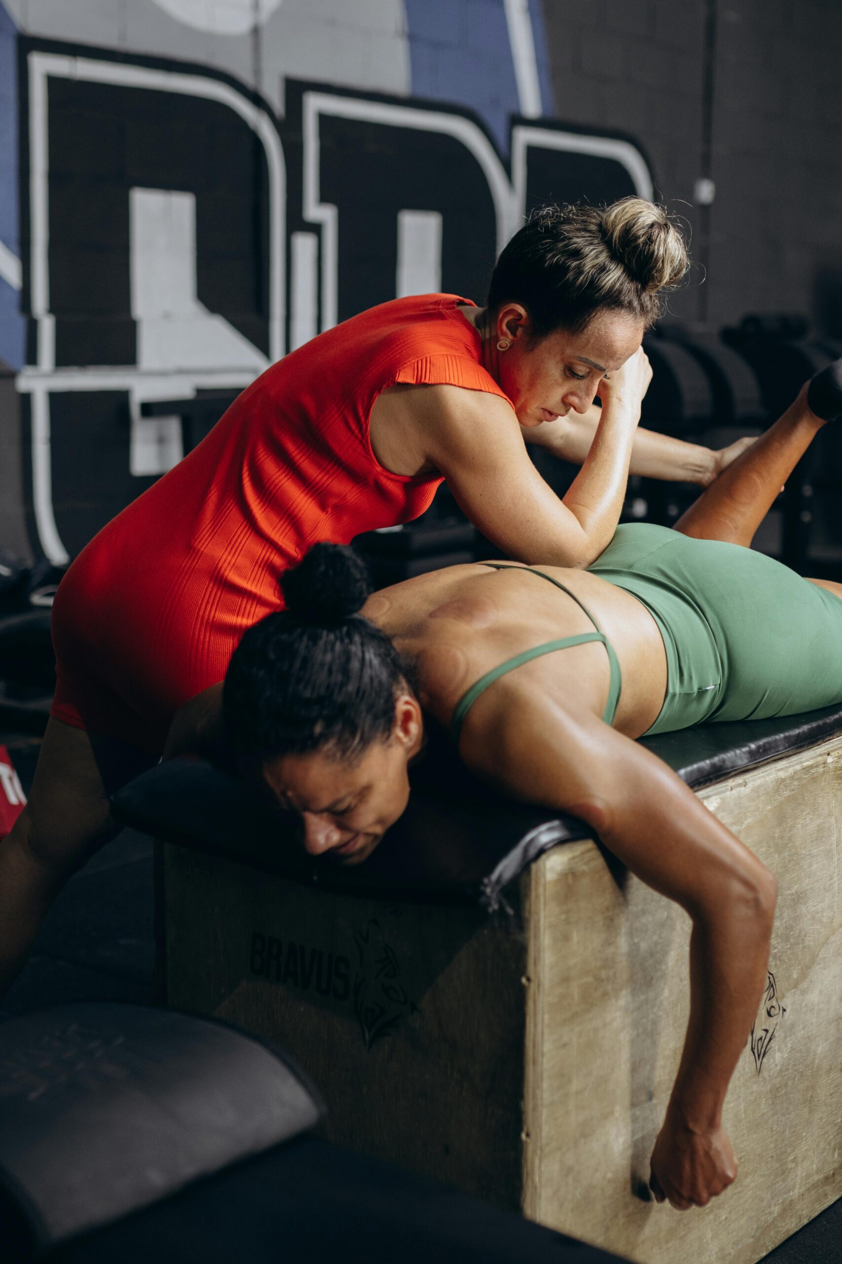 woman laying on stretch table getting lower back stretched by a female stretch therapist