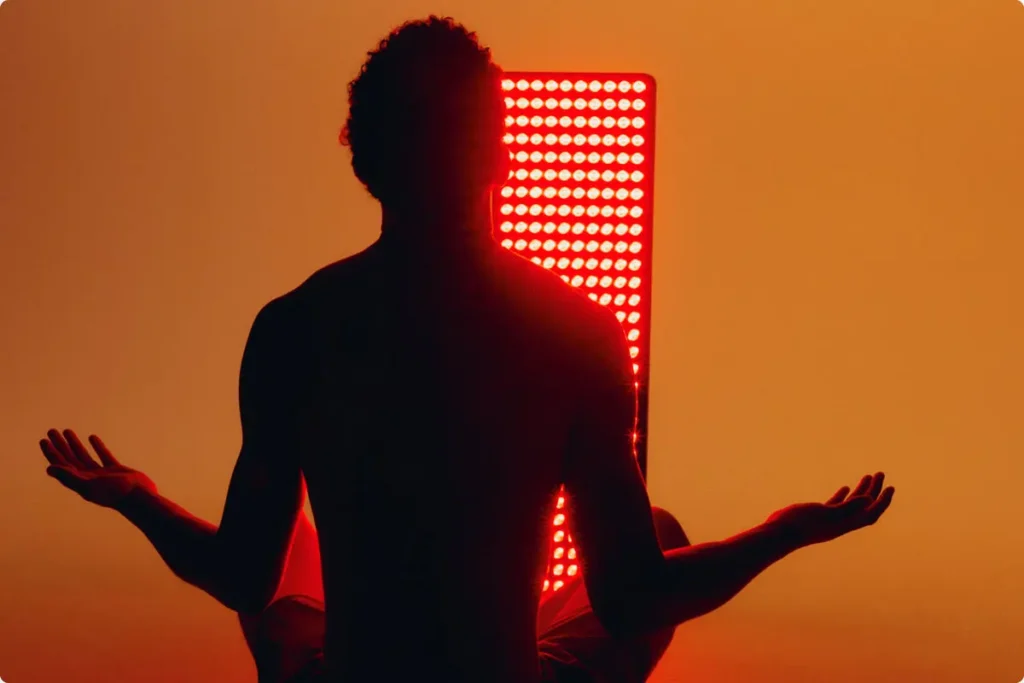 Man sitting at red light therapy panels at Body Reset in Clinton MD